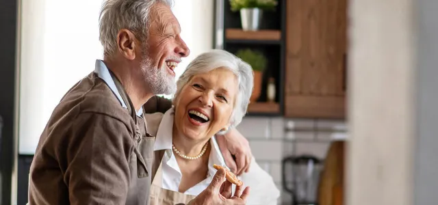Happy senior couple having fun in the kitchen